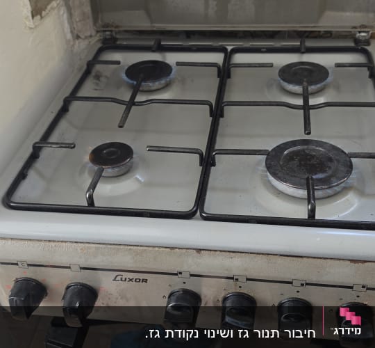 כיריים גז פועלות עם להבות כחולות דולקות בארבעת המבערים